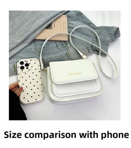 Mini sac bandoulière blanc en cuir comparé à la taille d'un smartphone moderne