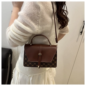 Detailed view of a vintage brown crossbody bag with retro pattern and gold lock