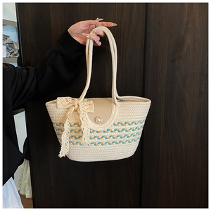 Detail of handwoven tote bag with lace bow, colorful stripes and pearl button closure