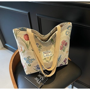 Detailed view of floral jacquard fabric and woven handles on a vintage tote bag