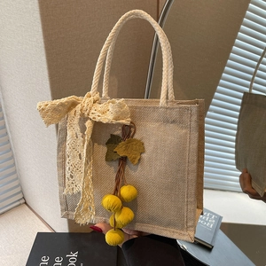 Chic light brown woven lunch bag with beige lace bow and yellow fruit charm pendant