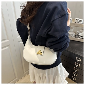 White hobo shoulder bag with gold triangular clasp shown in a lifestyle interior