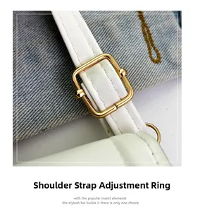 Détail de la boucle réglable dorée sur un sac à bandoulière blanc avec des coutures soignées
