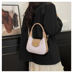 Detail of light pink woven texture bag with tan leather trim and golden metal clasp