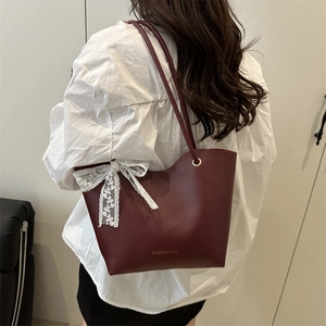 Burgundy faux leather tote bag with white lace bow decoration and long shoulder straps