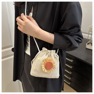 Dettaglio della borsa a secchiello in paglia intrecciata con girasole 3D e coulisse