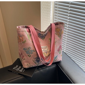 Detailed close-up of pink tulip jacquard fabric and brand label on large tote bag