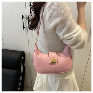 Detail of pink crescent underarm bag with gold buckle on shoulder of a model