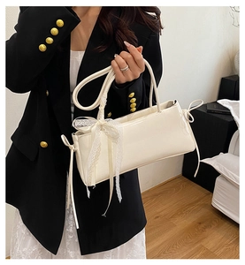 Chic cream white shoulder bag featuring a lace bow detail styled with a black blazer
