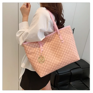 Detail shot of pink quilted tote bag with letter print and golden M logo charm
