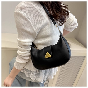 Detail of a black crescent shoulder bag with golden triangle buckle on white knitwear