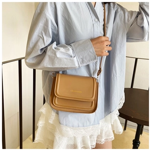 Sac bandoulière en cuir PU caramel avec logo porté par un mannequin en détail