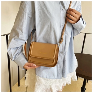 Gros plan d'un sac bandoulière vintage marron avec lettrage Classic Bag doré et fine sangle