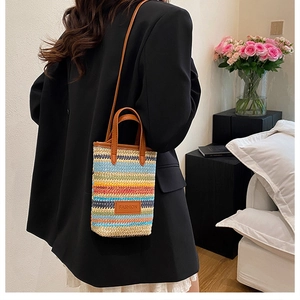 Close-up of a colorful striped woven mini bag with FASHION leather patch and brown handles