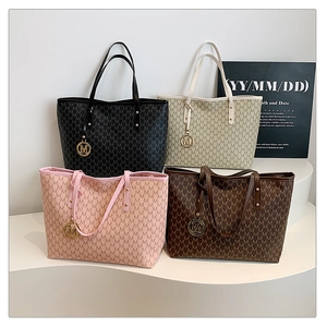 Detail of multi-color tote bags with letter patterns and golden M metal charms