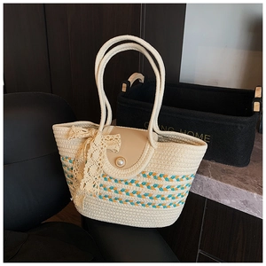 Detail of woven straw tote bag with pearl closure and elegant lace bow decoration