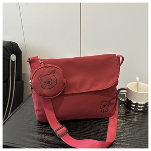 Detail of dark red messenger bag with cartoon bear print and small round coin purse