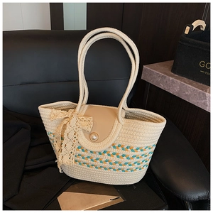 Detail of woven straw tote bag with lace bow, pearl clasp and colorful striped bottom