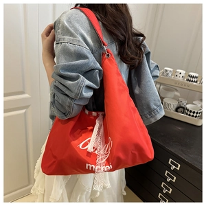 Detail of red nylon tote bag featuring white lace ribbon and morei typography print