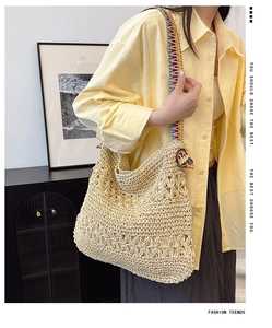 Detail of hollow-out woven straw tote bag with bohemian jacquard shoulder strap