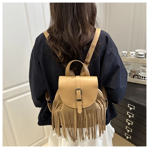 Detail eines hellbraunen Boho-Rucksacks mit Lagenquasten und Metallschnallenverschluss