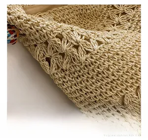 Close-up of woven hollow pattern on a straw handbag with decorative colorful tassel