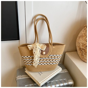 Woven straw tote bag detail with pearl buckle closure and elegant lace bow decoration