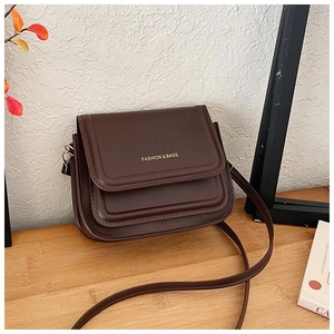Détail du sac bandoulière vintage marron foncé avec lettrage doré et crochets en métal