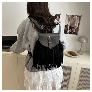 Detail eines böhmischen schwarzen Fransenrucksacks mit Metallschnalle im Lifestyle-Stil