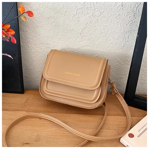Détail d'un sac à bandoulière vintage camel avec surpiqûres et fermeture à rabat