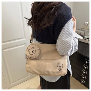 Detail of beige nylon messenger bag with cartoon bear print and small round coin purse