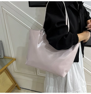 Detail of adjustable silver buckle on large beige tote bag with smooth finish