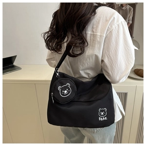 Detail of black crossbody bag with mini pouch and cartoon bear print for daily use