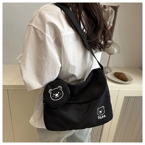 Detail of the black nylon messenger bag featuring a cute white bear print and coin pouch
