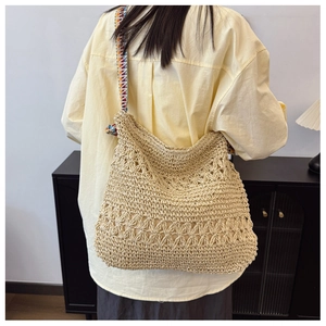 Detailed back view of large straw tote bag with colorful ethnic style shoulder strap