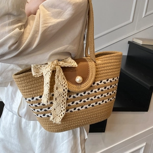Handwoven straw tote bag with pearl button and lace bow detail for summer beach use