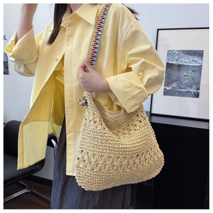 Detail of bohemian hollow-out woven tote bag with a colorful geometric jacquard strap