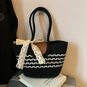 Large woven beach tote bag in black and white stripes with a lace bow decoration
