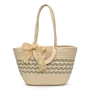 Large woven straw tote bag with blue-orange stripes and lace bow on white background