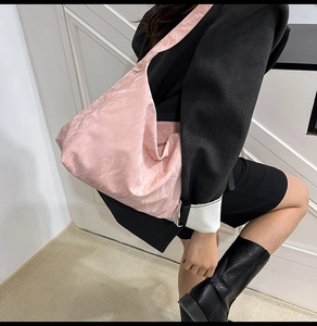 Pink oversized hobo shoulder bag featuring unique wrinkled nylon texture and wide strap
