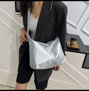 Detail of silver metallic tote bag featuring trendy pleated texture and spacious design