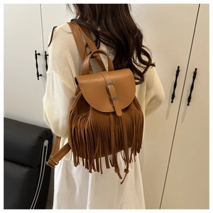Detailansicht eines böhmischen Quasten-Rucksacks in Karamellbraun am Model im Haus