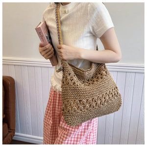 Detail of handwoven shoulder bag with hollow flower pattern and wide colorful strap
