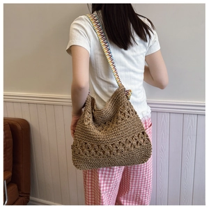 Detail of hollow-out floral woven tote bag with a colorful bohemian geometric strap