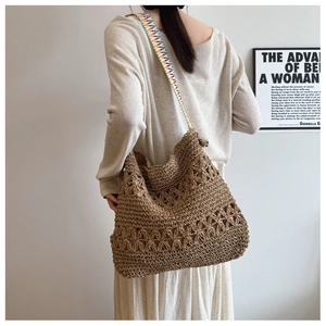 Detailed view of the woven tote bag featuring floral crochet patterns and a colorful strap