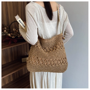 Detail of hollow floral woven straw tote bag with colorful patterned wide strap