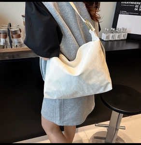 Close-up of white pleated leather texture and golden metal buckle on tote bag