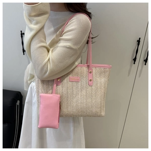 Detail of beige straw tote bag with pink leather trim and matching small hanging pouch