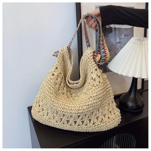 Detail of hollow floral knit texture on beige large capacity straw tote bag with strap