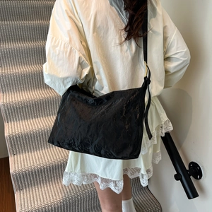 Large black crinkled tote bag with adjustable shoulder strap and gold metal buckles
